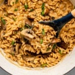 white pot of mushroom stroganoff with parsley and black pepper on marble background