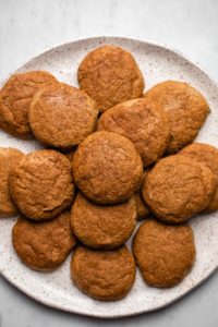 pile of snickerdoodle cookies on white speckled plate