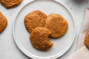 three cashew butter snickerdoodles on small grey plate on marble background