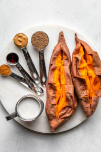 ingredients for sweet potato breakfast bowl on round white cutting board