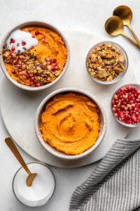 sweet potato breakfast bowls next to smaller bowls of topping ideas