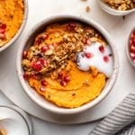 sweet potato breakfast bowl topped with granola, coconut yogurt, and pomegranate seeds