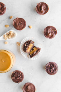 flatlay of peanut butter cups with peanuts and peanut butter jar