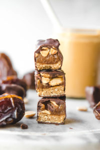 cross section of snickers bars with dates and peanut butter jar
