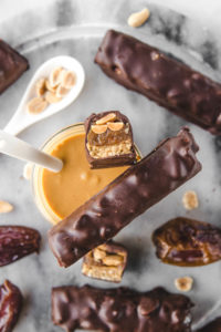 cross section of snickers bars with dates and peanut butter jar