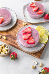Small Strawberry Cheesecake with lemon on wooden board