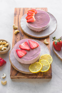 Small Strawberry Cheesecake with lemon on wooden board