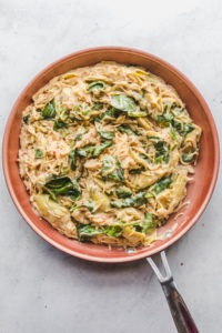 One Pot Spinach Artichoke Pasta in red pan
