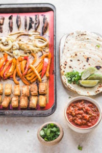 roasted vegetables and tofu on baking tray with tortillas and salsa