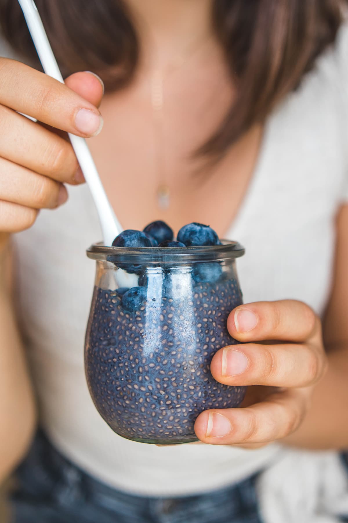 girl holding jar of blueberry chia seed pudding