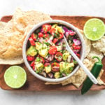 Avocado salsa on wood platter with cips