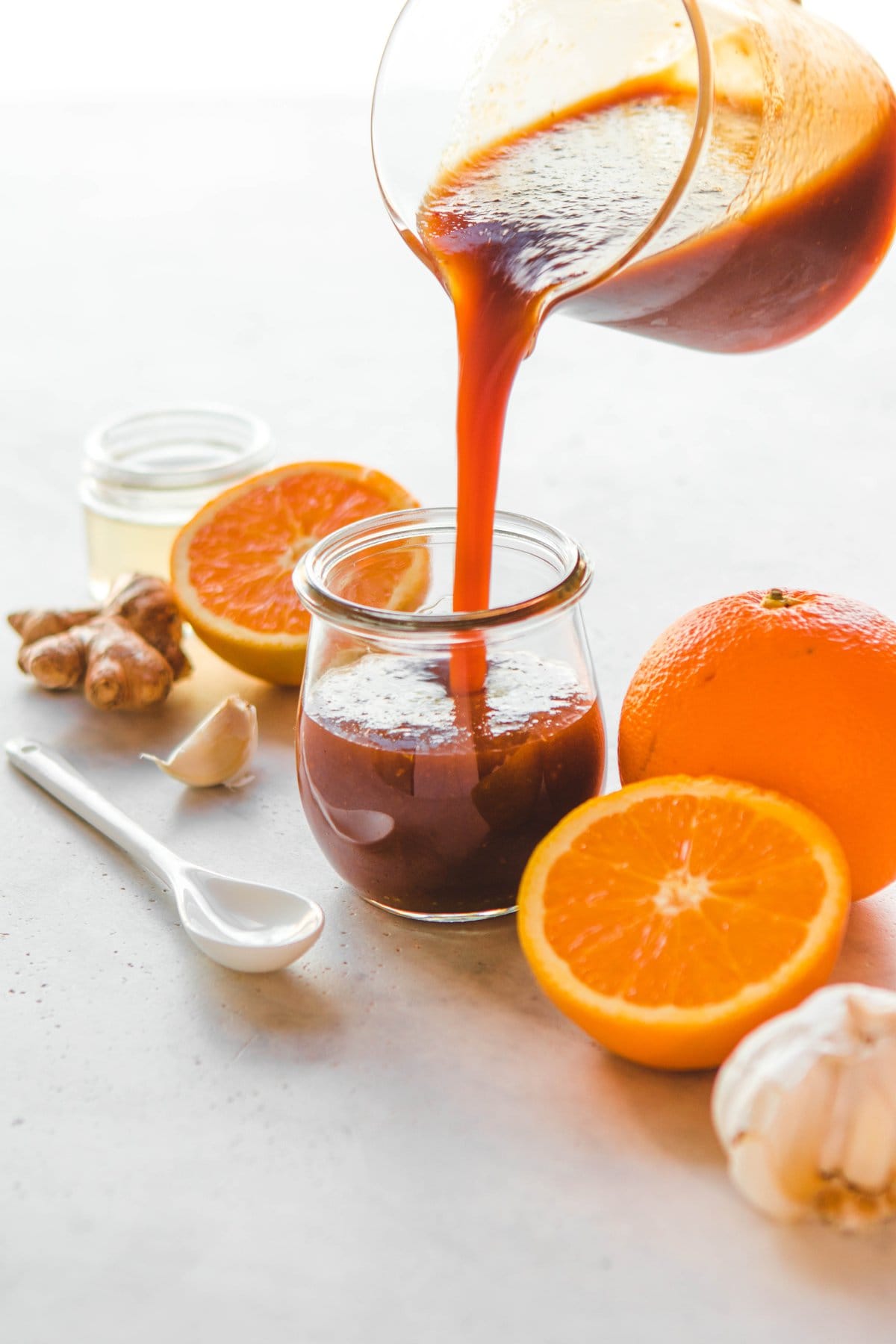 pouring orange sauce into glass jar