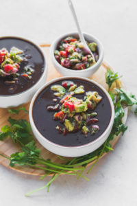 black bean soup in white bowls with salsa and cilantro