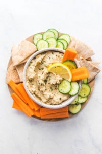baba ganoush in bowl with pita carrots and cucumber