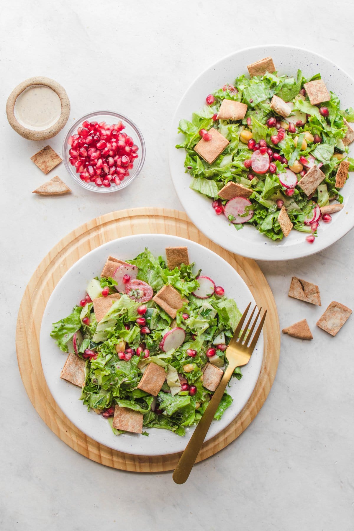 fattoush salad with pomegranate and dressing in bowls