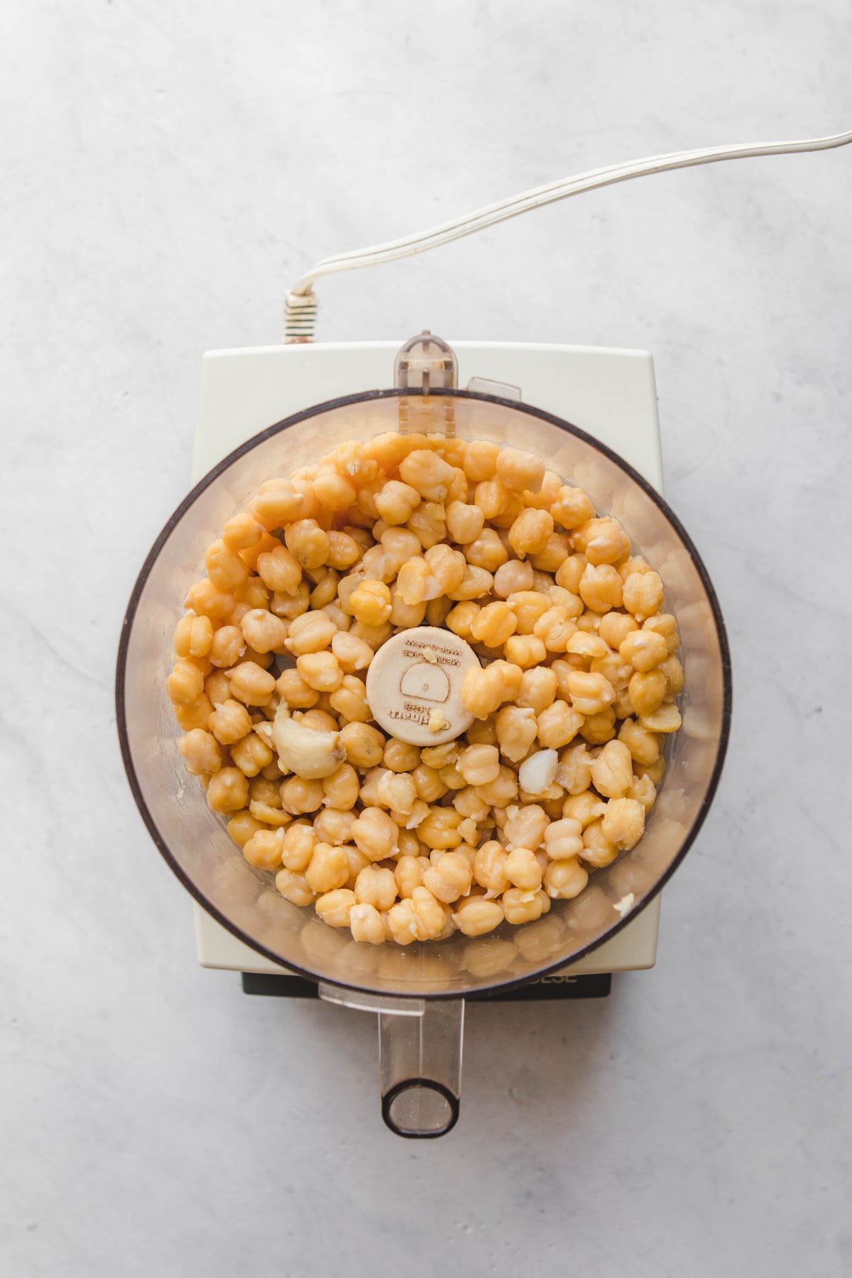 food processor with chickpeas and garlic