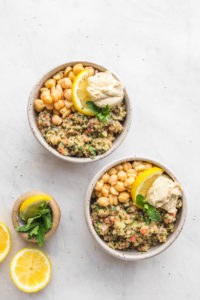 bowls of quinoa tabbouleh with hummus and lemon