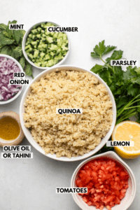 Ingredients for quinoa tabbouleh arranged around bowl of cooked quinoa. Clockwise text labels read parsley, lemon, tomatoes, olive oil or tahini, quinoa, red onion, mint, and cucumber