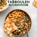 Bowl of quinoa tabbouleh with chickpeas and sliced pita bread