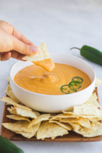 chip dipped in queso