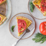 vegan quiche with tomatoes on white plate