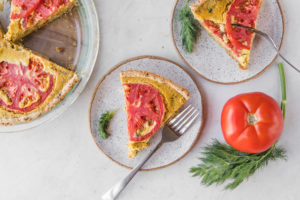vegan quiche with tomatoes on white plate