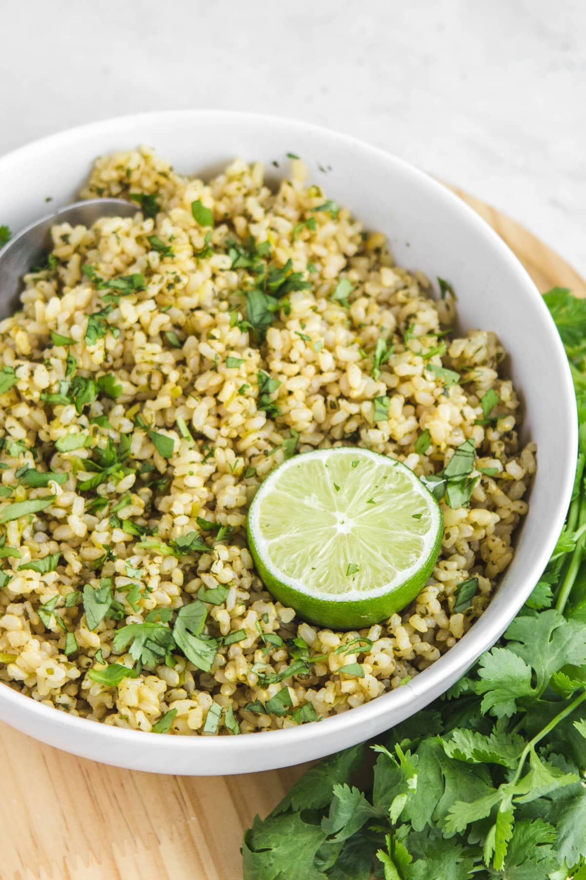 close up of cilantro lime rice in white bowl with lime wedge