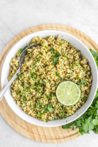 white bowl of cilantro lime rice with fresh cilantro