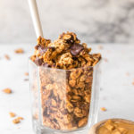 peanut butter cup granola in glass jar with white spoon