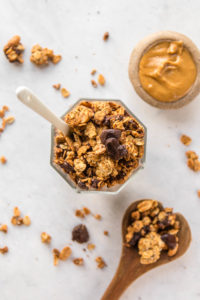 overhead view of peanut butter cup granola in glass jar with peanut butter