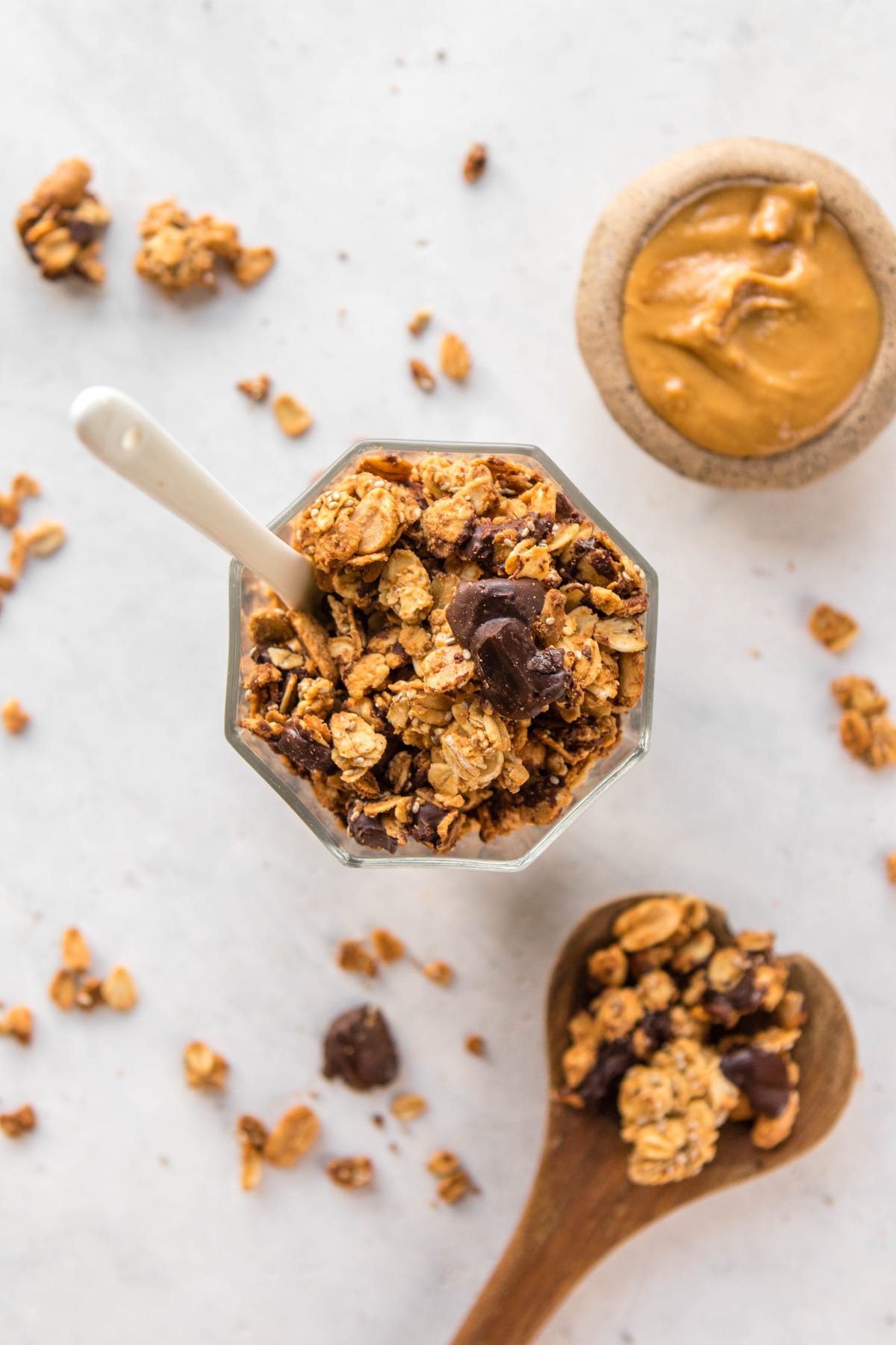 overhead view of peanut butter cup granola in glass jar with peanut butter