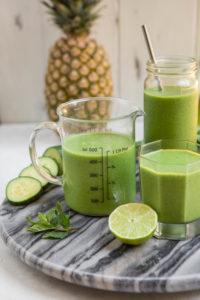 pineapple mint smoothie in pint glass measuring cup on marble board