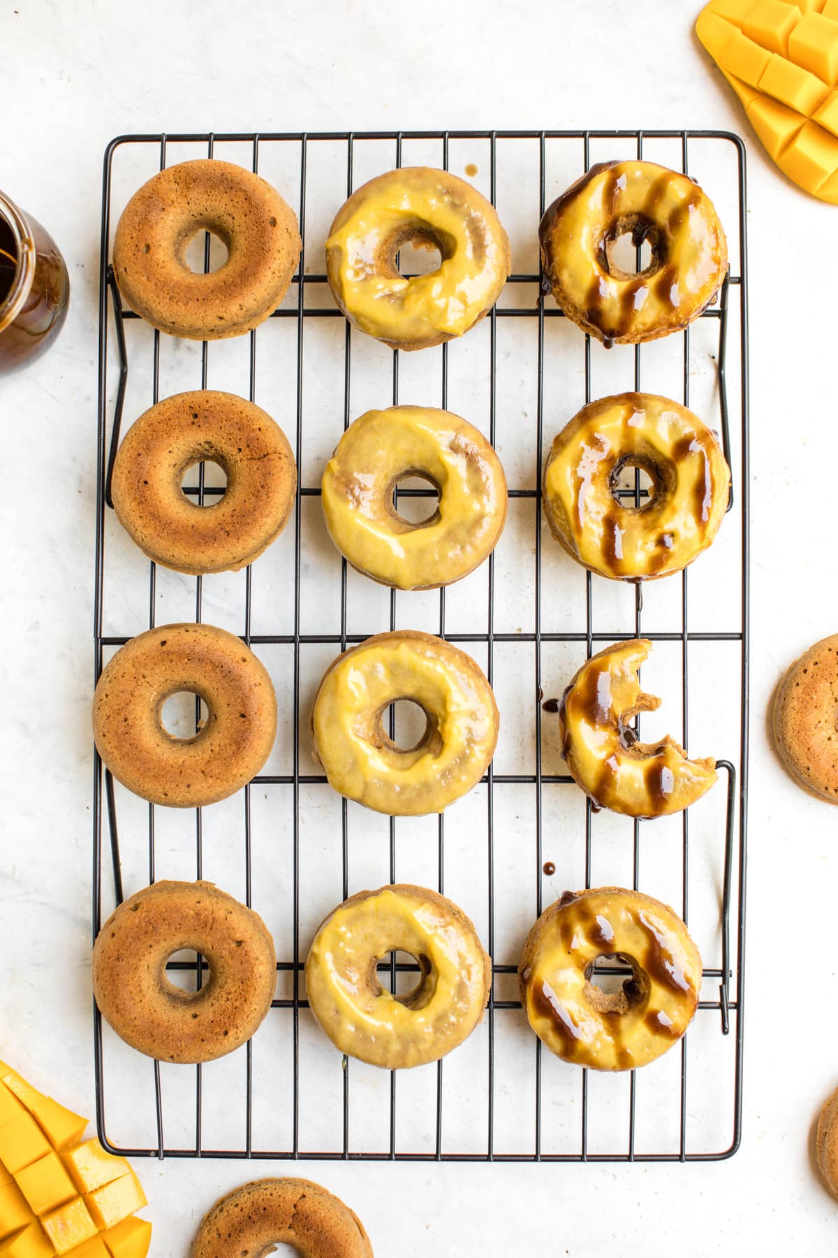 toasted coconut baked donuts on cooling rack with mango glaze