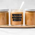 3 glass jars of toasted coconut butter with marble background