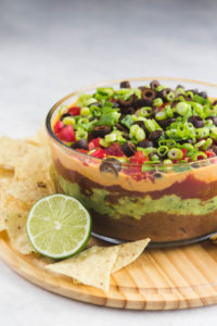 side shot of seven layer dip with lime and chips
