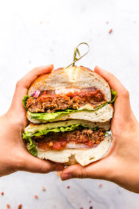 hands holding veggie burger cut in half