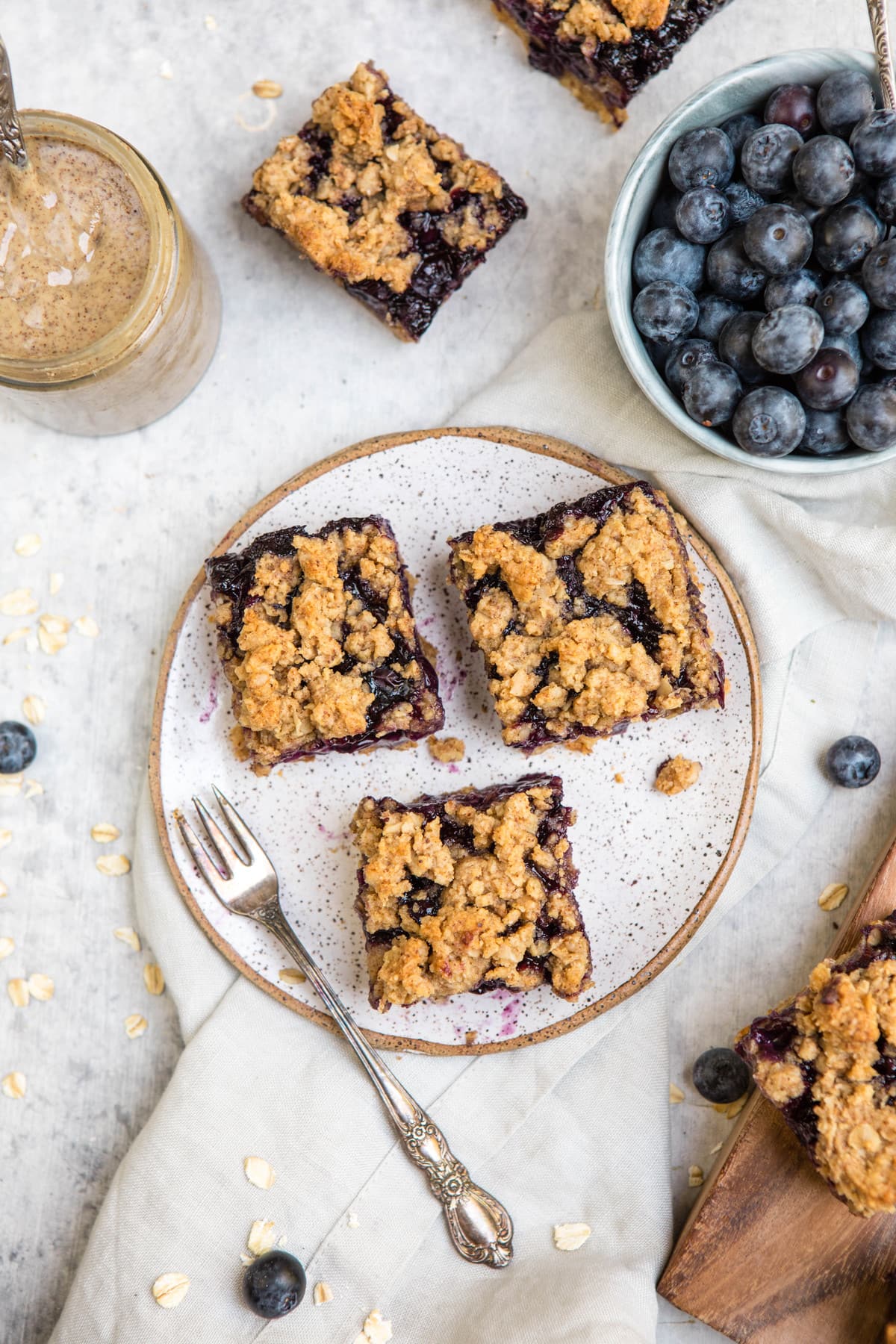 overhead shot of blueberry crumble bars on white plate