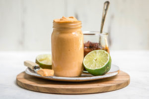 chipotle mayo in glass jar on wood cutting board