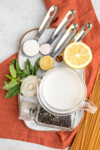 ingredients for garlic sauce pasta on white tray