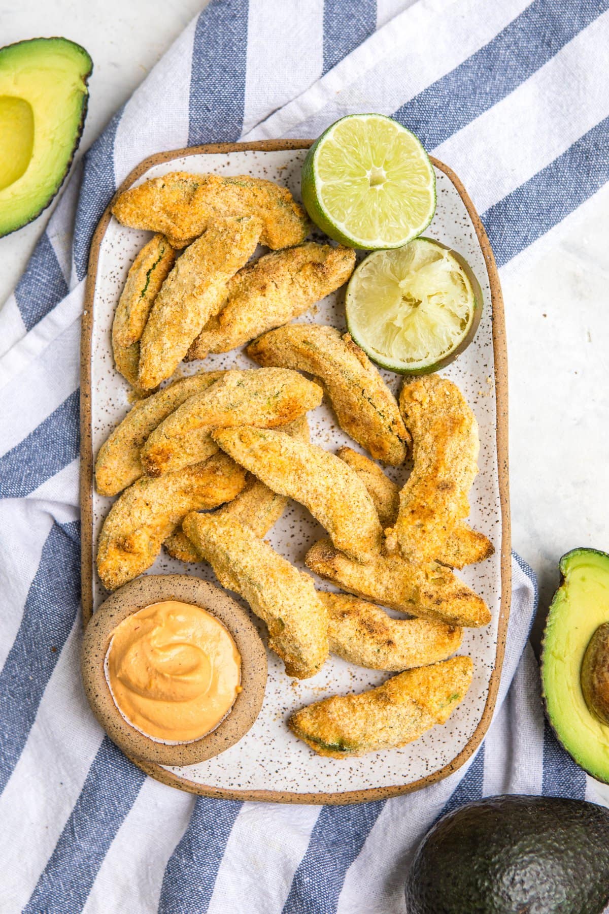 avocado fries on white tray with chipotle mayo and limes