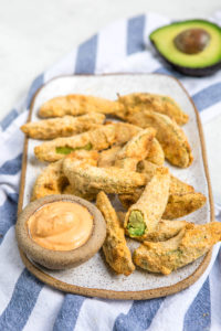 side view of avocado fries on white tray
