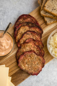 corned beef eggplant slices on wood cutting board