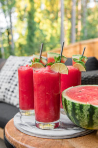watermelon slushies in glasses with lime on patio table
