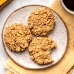three banana oatmeal breakfast cookies on white speckled plate on marble background