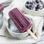 blueberry maqui popsicles on white towel and marble background