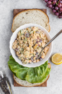 chickpeas salad with lettuce and bread on wood serving tray