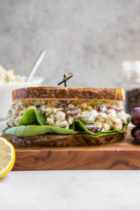 chickpea salad sandwich with grapes on wood serving platter