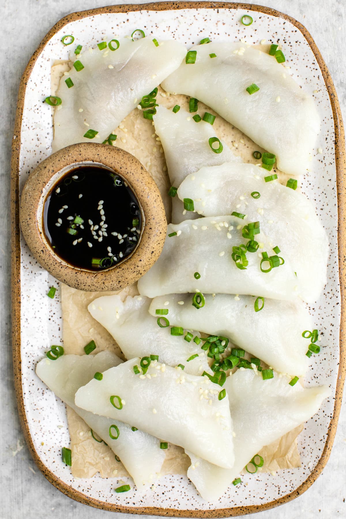 overhead shot of mushroom dumplings topped with green onion and sesame seeds
