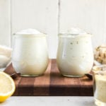 glass jars of vegan mayonnaise on wood cutting board