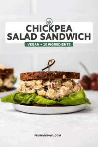 Chickpea salad sandwich on toasted bread with leafy lettuce on marble background